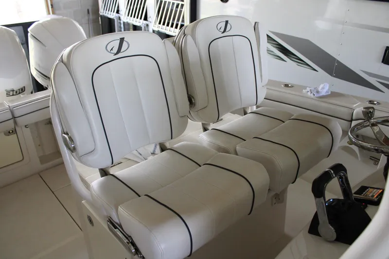 Slide: The Image of 2018 Jupiter 30 HFS boat interior with white cushioned seats and steering wheel. - 11
