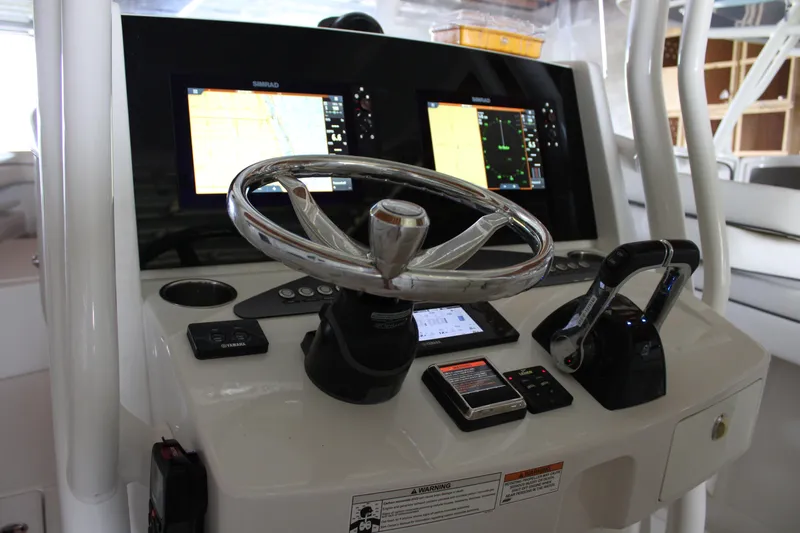 Slide: The Image of 2018 Jupiter 30 HFS boat dashboard with steering wheel and navigation screens. - 7