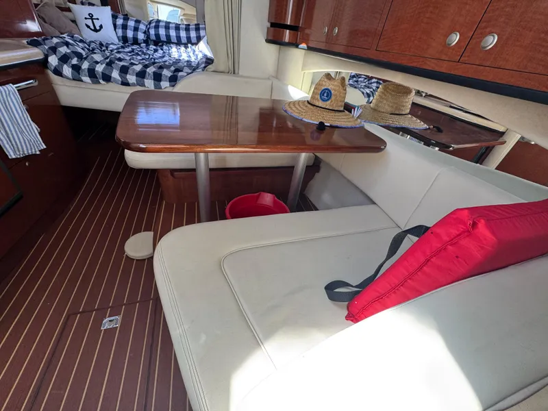 Slide: The Image of Interior of 2005 Sea Ray 300 Sundancer with seating, table, and nautical decor. - 12