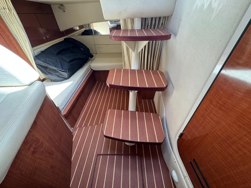 Slide: The Image of Interior of 2005 Sea Ray 300 Sundancer with wooden steps and seating area. - 16