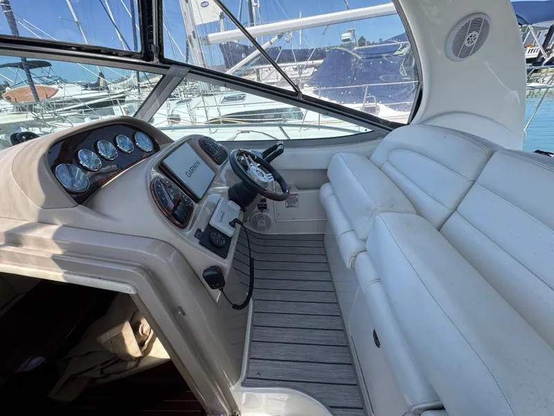 Slide: The Image of 2005 Sea Ray 300 Sundancer cockpit with Garmin navigation, white seating, and marina view. - 5