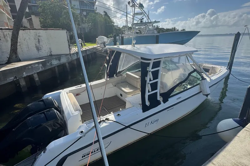 The Image of 2015 Boston Whaler 270 Vantage boat docked by the water, featuring dual engines. - 0