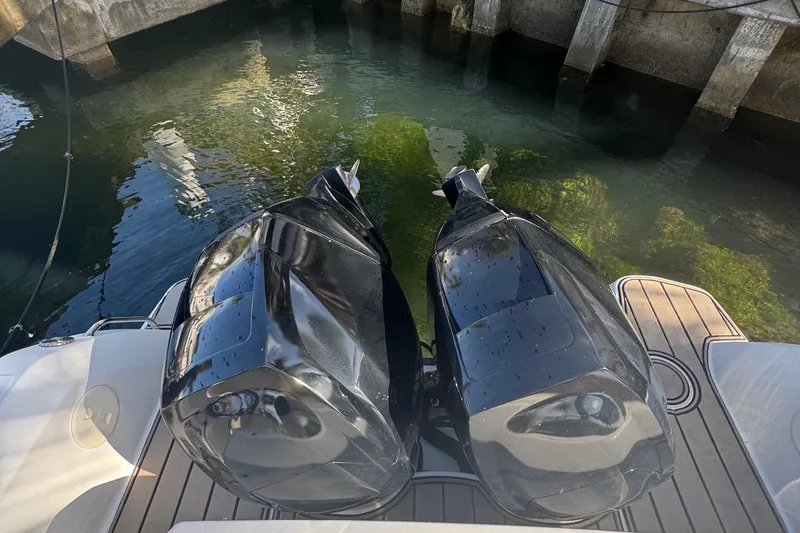 Slide: The Image of Twin outboard motors on a 2015 Boston Whaler 270 Vantage, docked in clear water. - 10