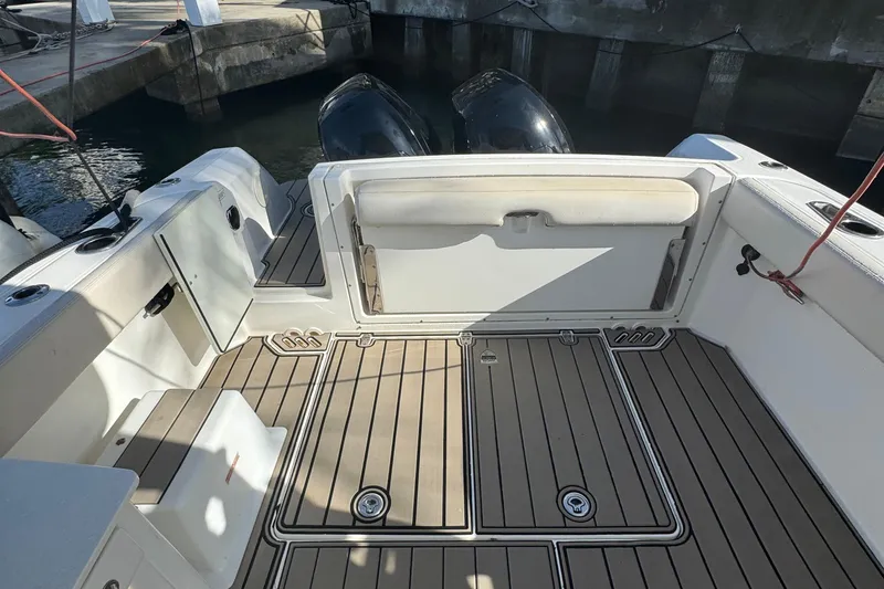Slide: The Image of 2015 Boston Whaler 270 Vantage boat deck with seating and twin engines at dock. - 3
