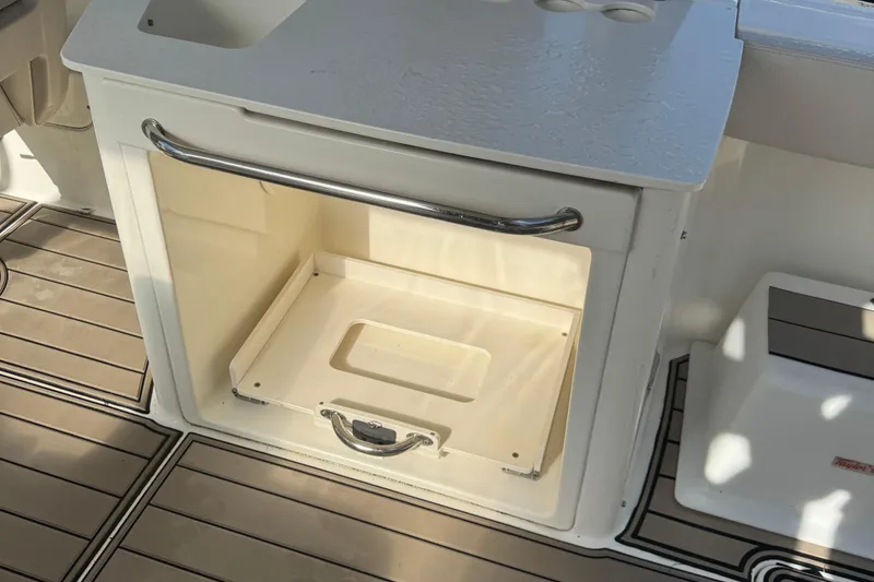 Slide: The Image of 2015 Boston Whaler 270 Vantage storage compartment with stainless steel handle and non-slip flooring. - 4