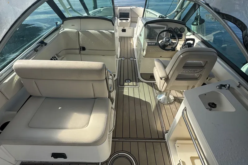 Slide: The Image of 2015 Boston Whaler 270 Vantage interior with seating, steering wheel, and sink. - 9