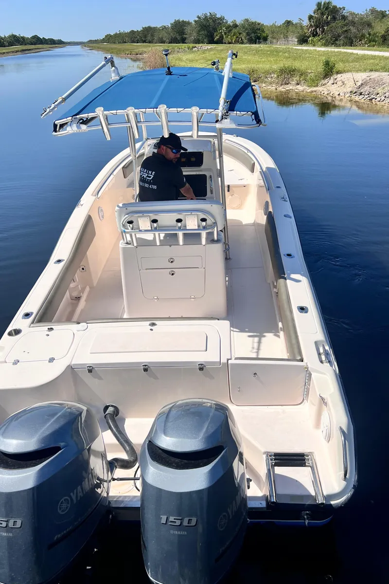 Slide: The Image of 2004 Grady-White 257 Advance CC boat with dual Yamaha 150 engines on a calm waterway. - 11