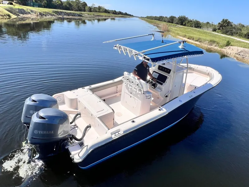 Slide: The Image of 2004 Grady-White 257 Advance CC boat with dual Yamaha engines on a calm waterway. - 5