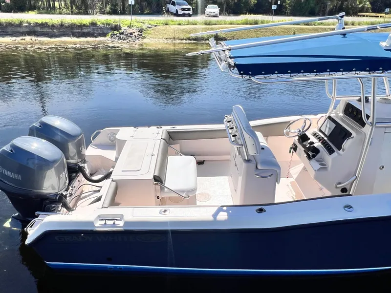 Slide: The Image of 2004 Grady-White 257 Advance CC boat with twin Yamaha engines, docked on calm water. - 6