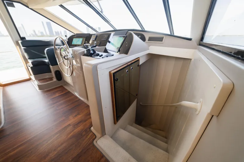 Slide: The Image of 1999 Bayliner 5788 yacht helm with modern controls and wooden flooring. - 29
