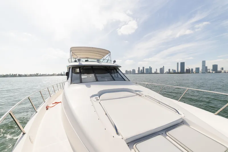 Slide: The Image of 1999 Bayliner 5788 yacht cruising near city skyline under clear sky. - 3