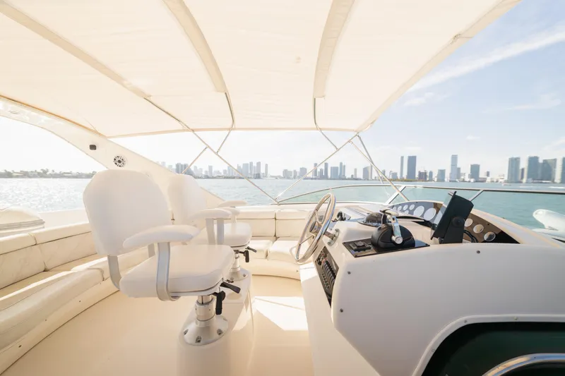 Slide: The Image of Luxurious 1999 Bayliner 5788 yacht helm with city skyline view, featuring white seating and controls. - 34