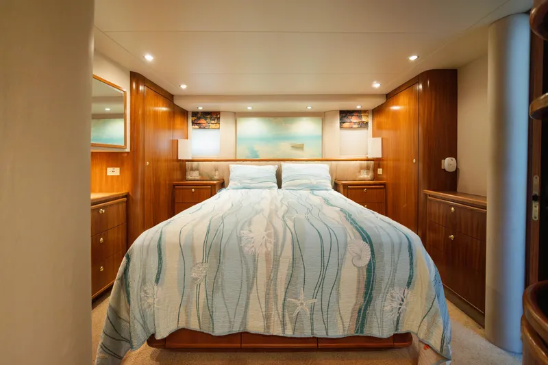 Slide: The Image of Luxurious 1999 Bayliner 5788 yacht bedroom with elegant wood paneling and cozy bedding. - 36
