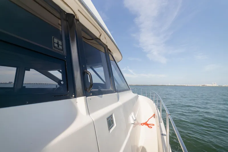 Slide: The Image of 1999 Bayliner 5788 yacht cruising on open water under clear blue sky. - 7