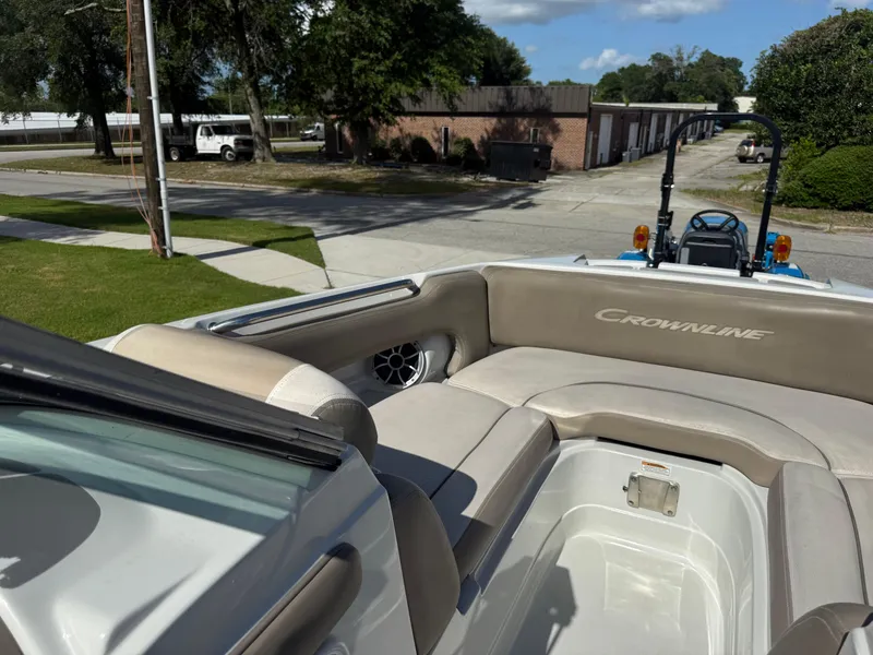 Slide: The Image of 2022 Crownline Eclipse E215 XS boat interior with beige seating and open storage area. - 13
