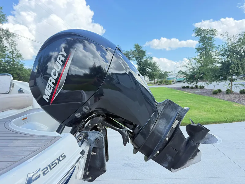 Slide: The Image of 2022 Crownline Eclipse E215 XS with Mercury outboard motor, parked on a sunny day. - 23