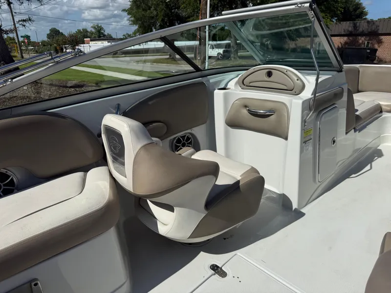 Slide: The Image of 2022 Crownline Eclipse E215 XS boat interior with beige seating and modern dashboard. - 9