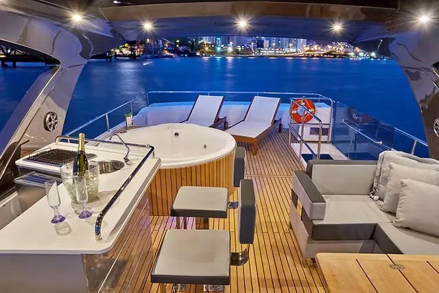 Slide: The Image of Luxurious Schaefer 770 yacht deck with jacuzzi, bar, and city skyline view, 2026 model. - 27