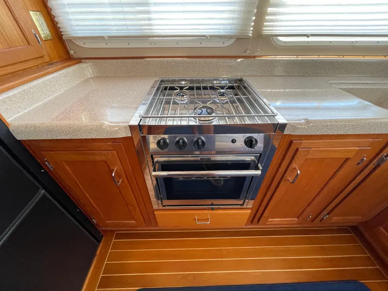 Slide: The Image of Galley kitchen in 2006 American Tug 34 with stove and wooden cabinetry. - 11