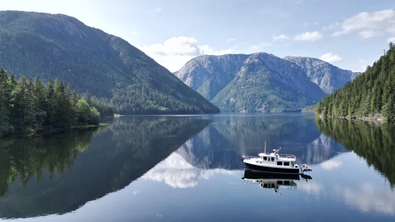 Slide: The Image of American Tug 34 (2006) on serene lake with mountain reflections. - 3