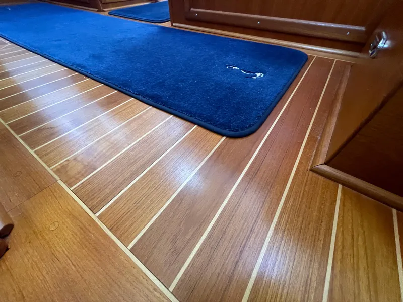 Slide: The Image of Teak flooring with blue carpet in 2006 American Tug 34 interior. - 32