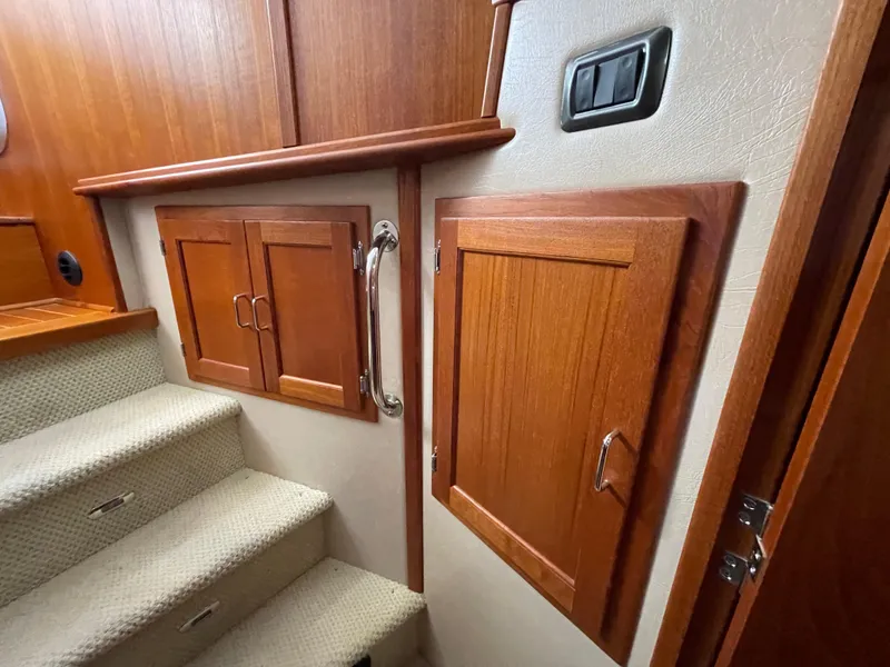 Slide: The Image of Interior of 2006 American Tug 34 with wooden cabinets and carpeted stairs. - 34