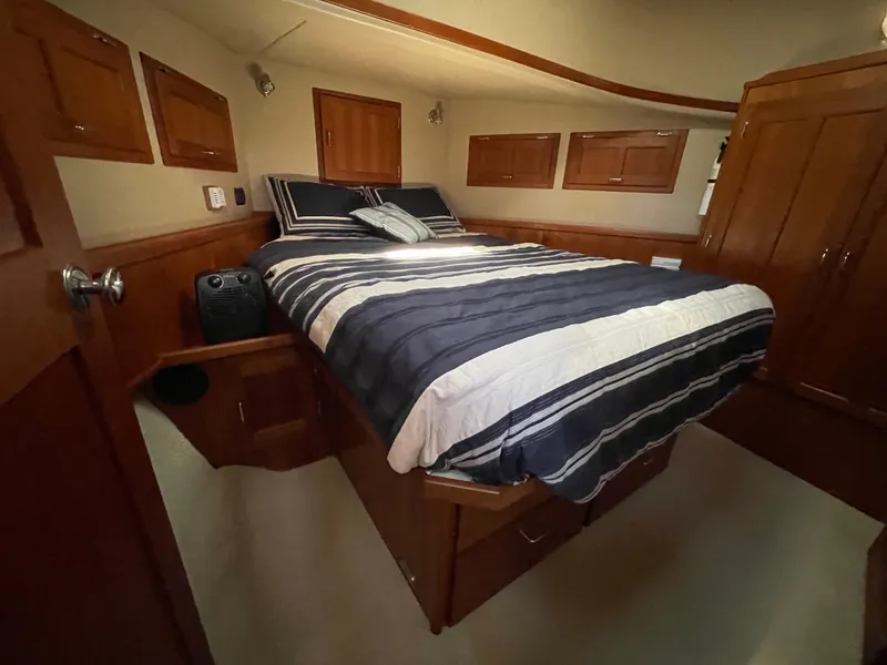 Slide: The Image of Cozy bedroom in 2006 American Tug 34 with striped bedding and wooden cabinetry. - 38
