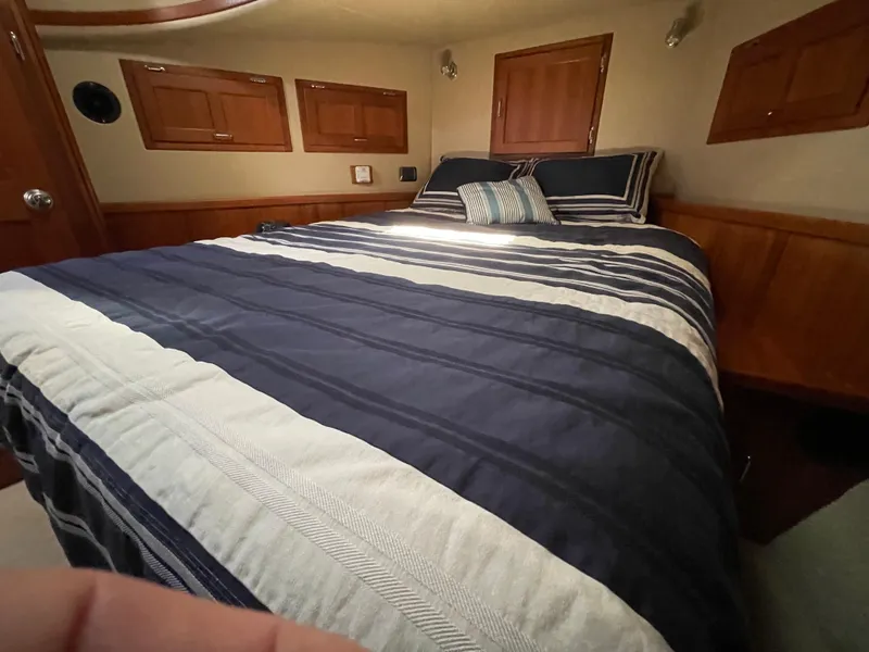 Slide: The Image of Cozy bedroom in 2006 American Tug 34 with striped bedding and wooden accents. - 39