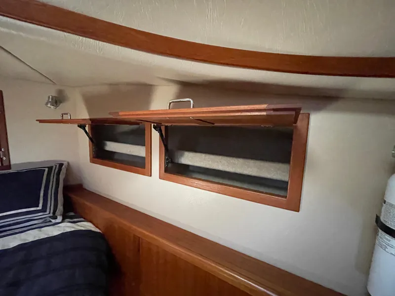 Slide: The Image of 2006 American Tug 34 interior with wooden storage compartments and cozy bedding. - 44