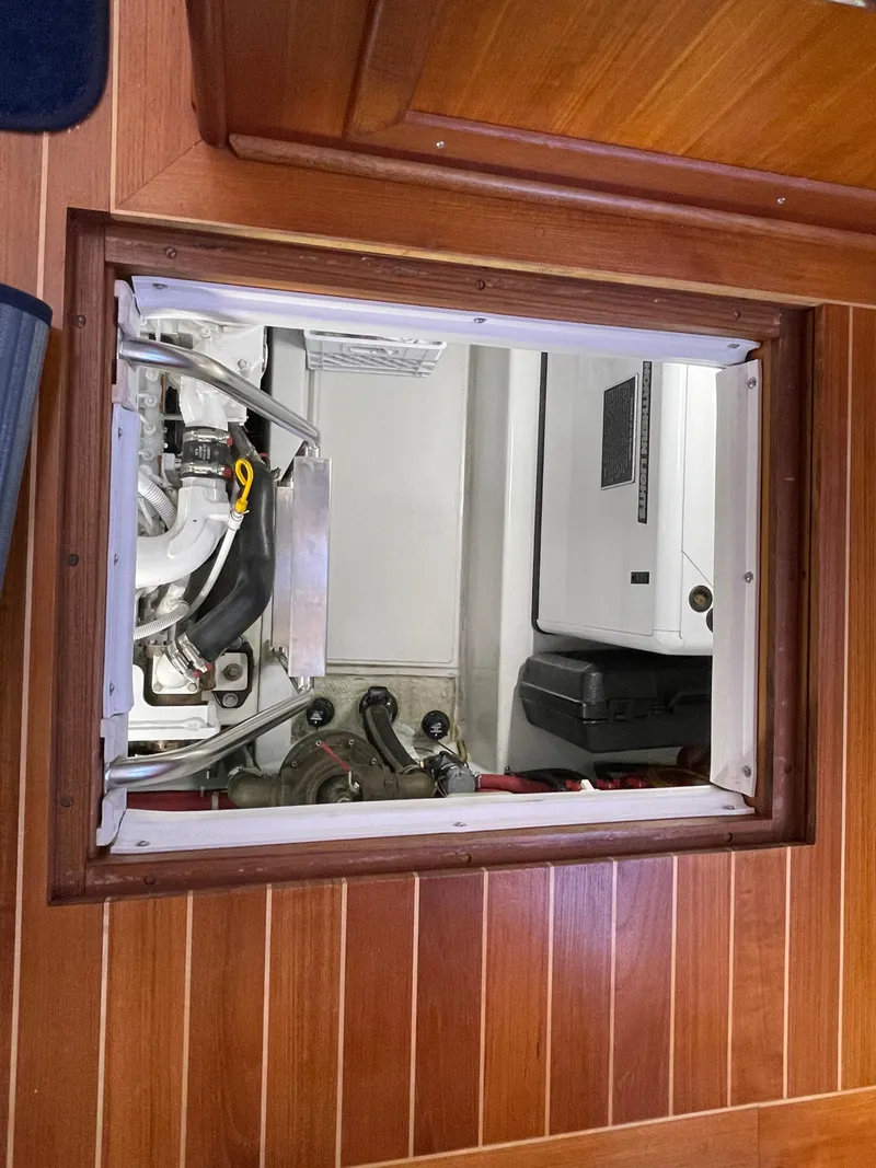 Slide: The Image of Engine compartment of a 2006 American Tug 34, featuring wooden flooring and visible machinery. - 46