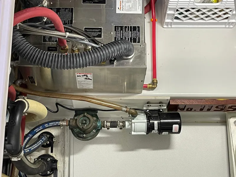 Slide: The Image of Engine room of a 2006 American Tug 34 with various hoses and mechanical components. - 52