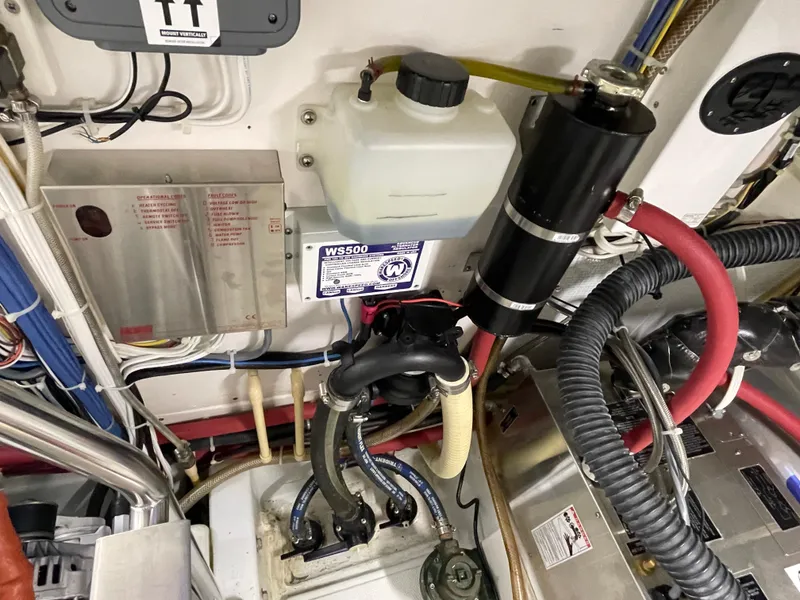 Slide: The Image of Engine room of a 2006 American Tug 34 with various mechanical components and wiring. - 53