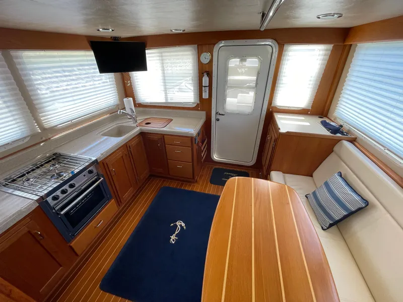 Slide: The Image of Interior of 2006 American Tug 34 with kitchen, seating, and TV. - 6