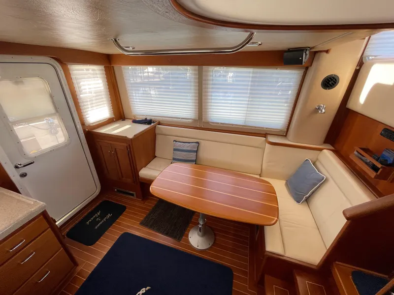 Slide: The Image of Interior of 2006 American Tug 34 with cozy seating and wooden table. - 7