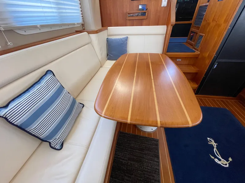 Slide: The Image of Interior of 2006 American Tug 34 with wooden table and cushioned seating. - 9