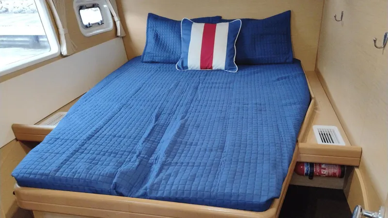 Slide: The Image of Cozy cabin interior of 2008 Lagoon 420 with blue bedding and nautical pillow. - 17