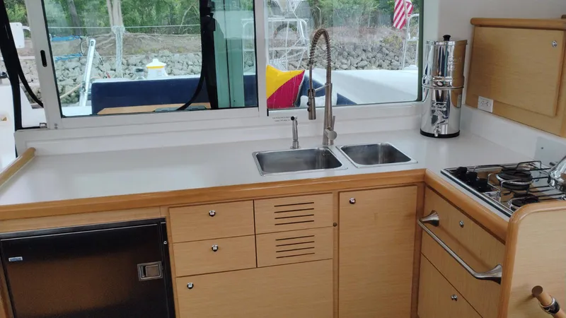 Slide: The Image of Interior of 2008 Lagoon 420 yacht kitchen with sink, stove, and wooden cabinetry. - 20