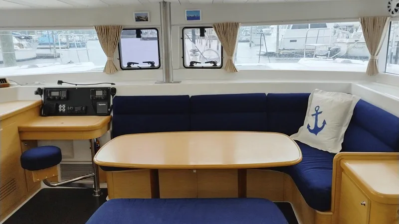 Slide: The Image of Interior of 2008 Lagoon 420 catamaran with blue seating and wooden table. - 22