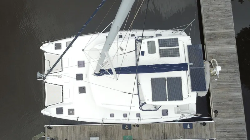Slide: The Image of Aerial view of a 2008 Lagoon 420 catamaran docked, featuring solar panels. - 28