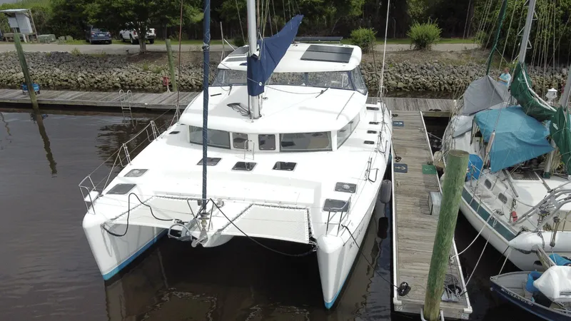 Slide: The Image of 2008 Lagoon 420 catamaran docked at a marina, viewed from the front. - 29