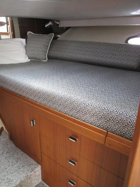 Slide: The Image of 1989 Tiara Yachts 3300 Open cabin interior with patterned bedding and wooden storage drawers. - 4