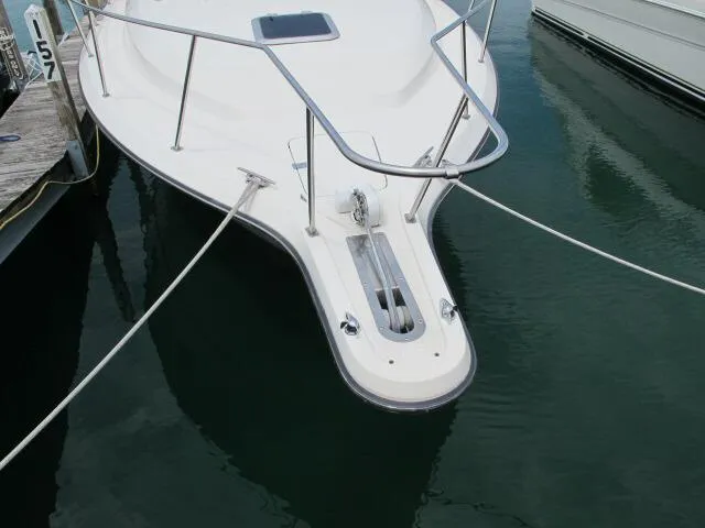 Slide: The Image of Bow of 1989 Tiara Yachts 3300 Open docked, featuring stainless steel railings and anchor. - 9