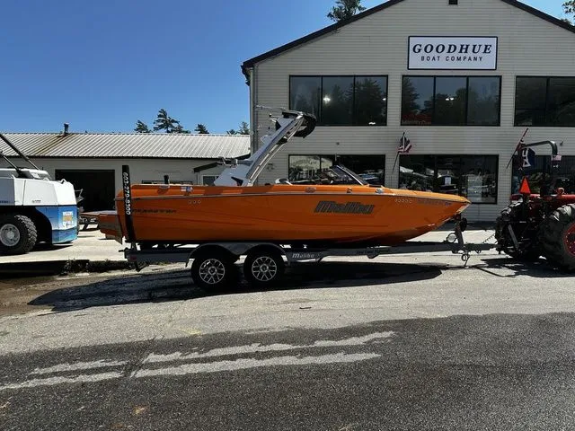 Slide: The Image of 2023 Malibu 21 LX boat on trailer outside Goodhue Boat Company. - 28