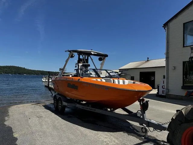 Slide: The Image of 2023 Malibu 21 LX boat on trailer by lakeside dock. - 29