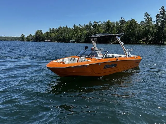Slide: The Image of 2023 Malibu 21 LX boat on a lake with forested shoreline. - 5