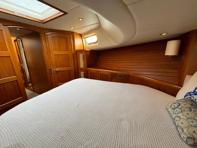 Slide: The Image of Luxurious cabin interior of 2009 Grand Banks 45 Eastbay SX yacht, featuring wood paneling and cozy bedding. - 41
