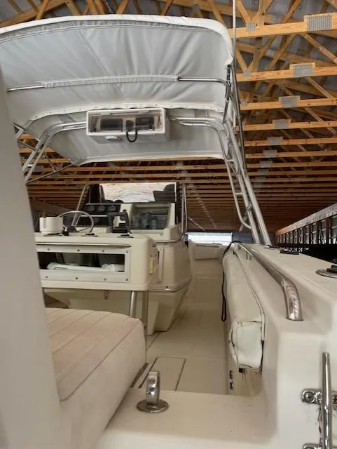 Slide: The Image of 1990 Donzi F-33 boat interior with canopy, stored in a wooden structure. - 10