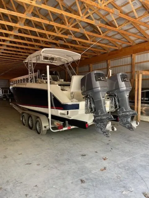 Slide: The Image of 1990 Donzi F-33 boat with dual outboard motors in a wooden storage facility. - 4