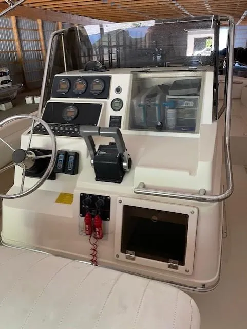 Slide: The Image of 1990 Donzi F-33 boat dashboard with steering wheel and control panel in a storage facility. - 9