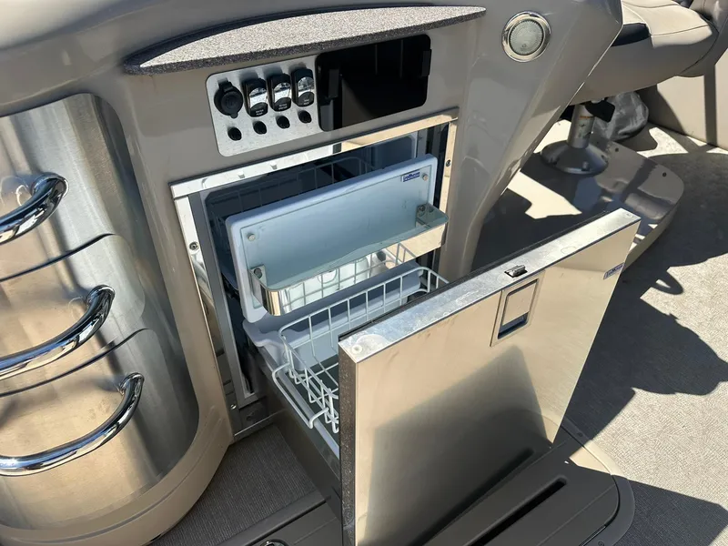 Slide: The Image of Open refrigerator on 2018 Avalon Catalina Platinum Entertainer boat, showcasing interior storage space. - 14